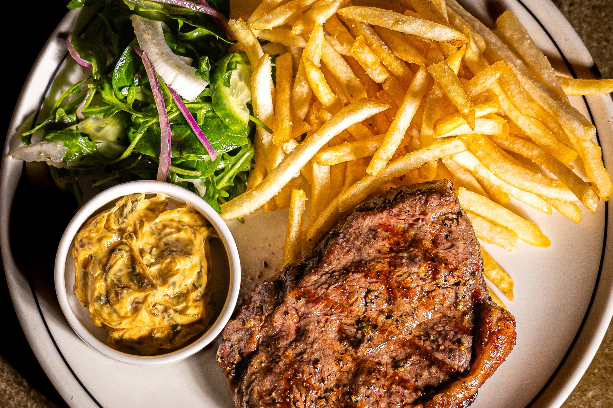 Sirloin Steak with Cowboy butter, shoestring fries and salad.